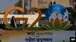 Seorang pejalan kaki berjalan melewati logo G20 yang baru diluncurkan di New Delhi, India, Kamis, 1 Desember 2022. India resmi menjadi Ketua Kelompok 20 Ekonomi Terkemuka (G20) 1 Desember 2022. (Foto AP/Altaf Qadri)