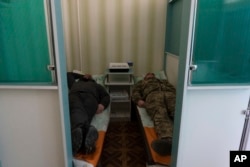 Ukrainian soldiers lay down during a electrosleep therapy session at a rehabilitation center in Kharkiv region, Ukraine, Friday, Dec. 30, 2022. (AP Photo/Vasilisa Stepanenko)