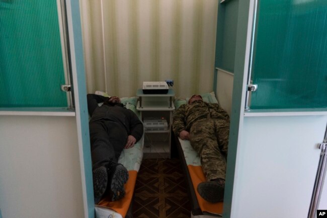 Ukrainian soldiers lay down during a electrosleep therapy session at a rehabilitation center in Kharkiv region, Ukraine, Friday, Dec. 30, 2022. (AP Photo/Vasilisa Stepanenko)