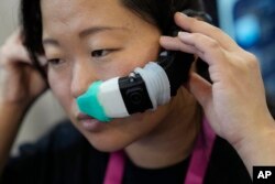 An exhibitor displays the OVR Technology ION 3 stand-alone wearable astatine  the OVR Technology booth during the CES tech show, Jan. 5, 2023, successful  Las Vegas.