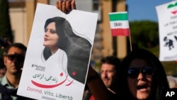 資料照片：人們在羅馬中部舉行的抗議集會上舉著在被伊朗道德警察拘押期間死亡的女子阿米尼的畫像。(2022年10月29日)