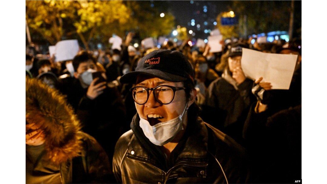 Para pengunjuk rasa berbaris di sepanjang jalan di China di Beijing pada 28 November 2022. (Foto: AFP)