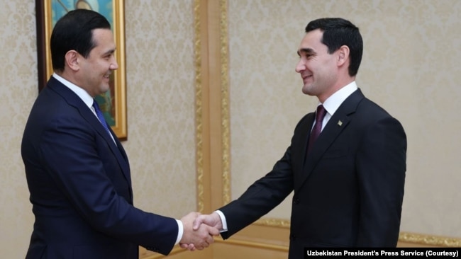 Turkmen President Serdar Berdimuhamedov, right, shakes hands with Sardor Umurzakov, chief of staff of Uzbek President Shavkat Mirziyoyev, Dec. 12, 2022, after the countries reached an agreement to double natural gas imports.