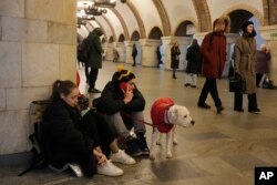 People rest in the subway station being used as a bomb shelter during a rocket attack in Kyiv, Ukraine, Thursday, Dec. 29, 2022. (AP Photo/Efrem Lukatsky)