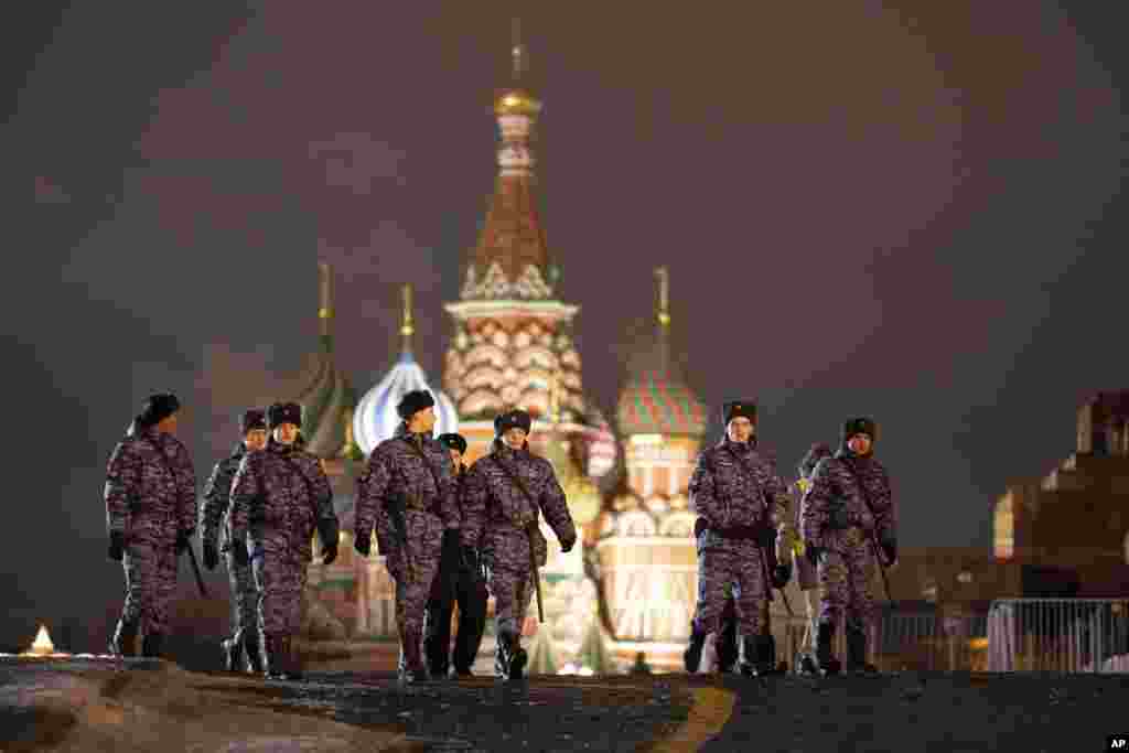 Police and the Rosguardia (National Guard) servicemen walk in the Red Square, closed for celebrations on the New Year's Eve, with the St. Basil's Cathedral, in Moscow, Russia, Dec. 31, 2022.