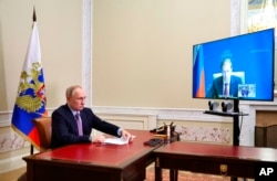 FILE - Russian President Vladimir Putin speaks via videoconference with Minister of Industry and Trade Denis Manturov, in St. Petersburg, Russia, Dec. 28, 2022. (Mikhail Klimentyev, Sputnik, Kremlin Pool Photo via AP)