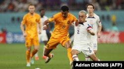 L'attaquant néerlandais Cody Gakpo (à g.) en duel face à l'Américain Sergiño Dest au Khalifa International Stadium à Doha le 3 décembre 2022. 