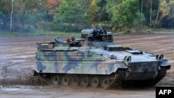 FILE - A Marder infantry fighting vehicle of the German armed forces Bundeswehr drives through the mud at a military training area in Munster, northern Germany, on Oct. 13, 2017. 