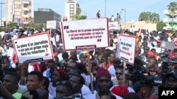 FILE - Senegalese journalists hold banners and shout slogans during the march for the release of their colleague Pape Ale Niang in Dakar, Nov. 18, 2022.