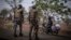 FILE: A police officer and a soldier from Benin stop a motorcyclist at a checkpoint outside Porga, Benin, March 26, 2022. Porga, in the Atakora region of northern Benin bordering Burkina Faso, has suffered violence linked to al-Qaida and the Islamic State group in the Sahel. 