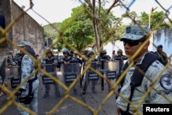 Agents of the National Guard stand guard as migrants (not pictured) gather to regularize their migration status outside Mexico's Commission for Refugee Assistance in Tapachula, Chiapas state, Mexico, Jan. 3, 2023.