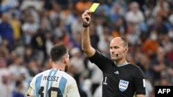 Wasit Spanyol Antonio Mateu Lahoz mengganjar pemain depan Argentina Lionel Messi sebuah kartu kuning saat laga perempat final Piala Dunia Qatar 2022 antara Belanda dan Argentina di Stadion Lusail, utara Doha, 9 Desember 2022. (Foto: Alberto PIZZOLI/AFP )