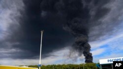 FILE - Smoke rises from an area controlled by Russian-backed separatist forces in Makiivka, 15 km east of Donetsk, eastern Ukraine, May 4, 2022. A HIMARS strike on the city Sunday leh at least 63 Russian soldiers left.