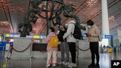 2022年12月29家庭成員在北京首都國際機場國際登機口前檢查護照