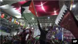 En esta imagen de archivo, aficionados ondean banderas qataríes y palestinas durante una transmisión del primer partido del Mundial, entre Qatar y Ecuador, en un gimnasio en la Ciudad de Gaza, el 20 de noviembre de 2022 (Foto: AP)