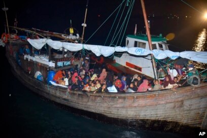 Pengungsi Rohingya duduk di perahu kayu saat tiba di Pelabuhan Krueng Geukueh di Aceh Utara, Kamis, 30 Desember 2021. (Foto: AP)