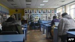 People work with their laptops in a public library in Irpin, northwest of Kyiv, on Dec. 23, 2022, amid the Russian invasion of Ukraine.