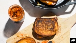 This image released by Milk Street shows a recipe for Kimchi Grilled Cheese with Ham. (Milk Street via AP)