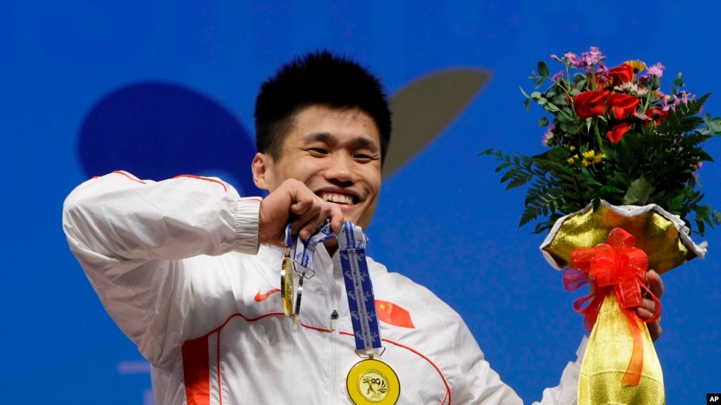 资料照片：中国运动员吕小军在韩国高阳举行的世界举重锦标赛的颁奖仪式上展示他获得的金牌。(2009年11月24日)(photo:VOA)