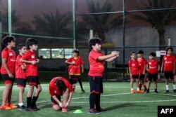 Anak-anak berlatih di lapangan sepak bola di Akademi Olahraga Cedars di ibu kota Qatar, Doha, 8 November 2022. ( KARIM JAAFAR/AFP)