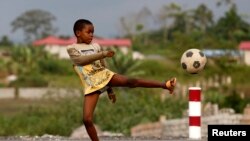 A boy plays soccer at the village of Bikuy on the outskirts of Bata, Equatorial Guinea, February 3, 2015. 