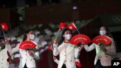 資料照 - 2021年在東京舉行的2020東京夏季奧運會開幕式上，香港代表隊隊員手舉香港區旗和印有“香港·中國”英文字的紅色扇子走進場內。