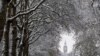 Trees are covered in snow in front of The Elizabeth Tower, more commonly known as Big Ben, in London, Dec. 12, 2022. 