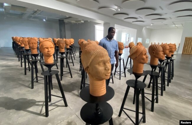 A man walks across a set up of terra cotta heads, a French woman collection representing the remaining Chibok school girls in captivity in Lagos, Nigeria, November 29, 2022. (REUTERS/Seun Sanni)