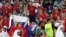 Seorang petugas keamanan tampak berusaha menenangkan seorang pendukung timnas Serbia dalam pertandingan Grup G Piala Dunia 2022 antara Serbia melawan Swiss yang digelar di Stadion 974 di Doha, Qatar, pada 2 Desember 2022. (Foto: Reuters/Carl Recine)