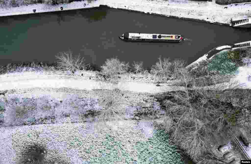 Peter Hilton mueve su barca por el Grand Union Canal hacia Milton Keynes, mientras continúa el frío, en Stoke Bruerne, Gran Bretaña. REUTERS/Andrew Boyers.