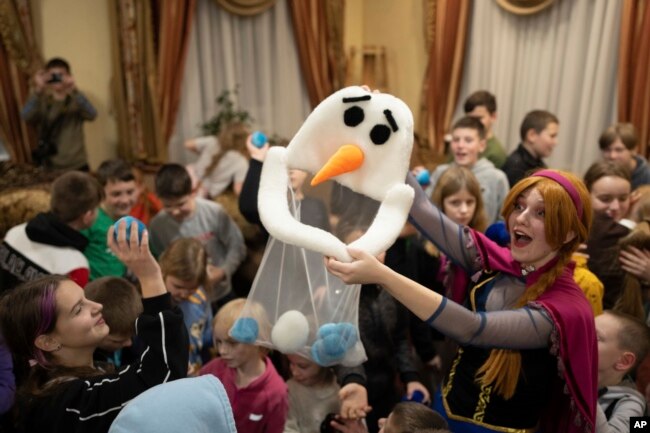 An actress performs for children at the Dzherelo rehabilitation center during celebrations for Saint Nicholas Day, in Kyiv, Ukraine, Monday, Dec. 19, 2022.(AP Photo/Evgeniy Maloletka)