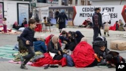 Unas personas descansan afuera de sus viviendas en Düzce, Turquía, el miércoles 23 de noviembre de 2022, luego de que un sismo de magnitud 5,9 azotó la región. (Depo Photos vía AP)