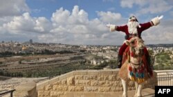 Wearing a Santa suit, Palestinian Issa Kassissieh poses for a picture while sitting on a camel at the Mount of Olives in Jerusalem, Dec. 6, 2022.