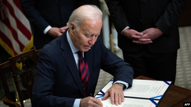 President Joe Biden signs a resolution to avert a nationwide rail shutdown, in the Roosevelt Room of the White House in Washington, DC, on Dec. 2, 2022.