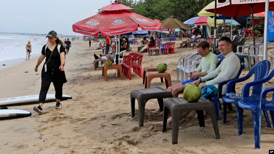 Sejumlah wisatawan terlihat di pantai Bali, 12 November 2022. Ombudsman RI menemukan bahwa data administrasi kependudukan bagi orang asing dan perubahan status kewarganegaraan masih belum terintegrasi. (Foto: Ilustrasi/AP)