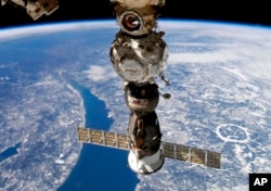 FILE - This undated handout photo taken by Russian cosmonaut Sergei Korsakov and released by Roscosmos State Space Corporation shows a Soyuz capsule of the International Space Station (ISS).