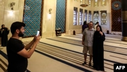 Canadian couple Dorinel and Clara Popa pose for a photo inside the Blue Mosque, during Qatar's 2022 World Cup, in Doha, Nov. 29, 2022.