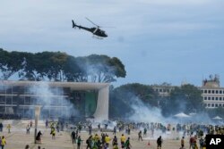 Demonstranti, pristalice bivšeg brazilskog predsjednika Jaira Bolsonara, sukobljavaju se s policijom dok upadaju u palatu Planalto u Braziliji, Brazil, u nedjelju, 8. januara 2023.
