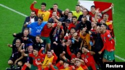 Morocco's Atlas Lions pose for a photo as they celebrate advancing to the semi finals of the 2022 FIFA World Cup