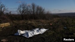 The bodies of dead Russian soldiers lay covered after being gathered by Ukrainian soldiers, to be exchanged for the bodies of fallen Ukrainian soldiers, in the former Russian occupied region of Donetsk Oblast, Ukraine, Dec. 14, 2022. 