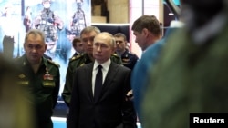 Presiden Rusia Vladimir Putin, Menteri Pertahanan Sergei Shoigu dan Kepala Staf Umum Angkatan Bersenjata Rusia Valery Gerasimov menghadiri pameran peralatan militer setelah pertemuan Dewan Kementerian Pertahanan di Moskow, 21 Desember 2022.