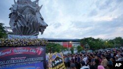 FILE - Pendukung klub sepak bola Arema FC berdoa bagi para korban penyerbuan pertandingan sepak bola 1 Oktober di luar Stadion Kanjuruhan di Malang, 3 Oktober 2022. (AP/Achmad Ibrahim)