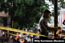 Seorang petugas polisi memasang garis penjagaan selama penyelidikan di Bandung, Jawa Barat sebagai ilustrasi. Kasus bunuh diri di Tanah Air sering terjadi pada siswa sekolah dan mahasiswa. (Foto: REUTERS/Willy Kurniawan)