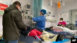 河北涿州市保定第二中心醫院裡醫護人員正在治療病人。 （美聯社2022年12月21日照片）