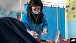 FILE - A Save the Children midwife provides Zarmina, 25, who is five months pregnant, with a pre-natal check-up in Jawzjan province in northern Afghanistan, Sunday, Oct. 2, 2022. (Save the Children via AP, File)