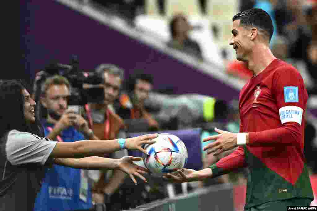 Cristiano Ronaldo recebe a bola de uma jovem apanha-bolas durante o jogo Portugal vs Suíça 