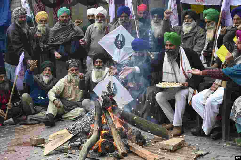 Farmers gather around a fire to celebrate Lohri festival while they protest the central and state government for loan waivers, pensions, crop insurance and minimum support price, in Amritsar, India.