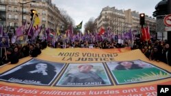 Activists hold a banner reading: "we want justice" in the 2013 killing of three Kurdish activists during a protest in Paris, Jan. 7, 2023. 