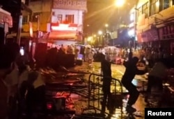 Demonstrators protesting over COVID-19 restrictions throw glass bottles towards riot police in Guangzhou, Guangdong province, China, in this screen grab taken from a social media video released, Nov. 30, 2022