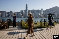 FILE - People are seen at the West Kowloon Cultural district overlooking Victoria Harbour in Hong Kong, Oct. 27, 2022.